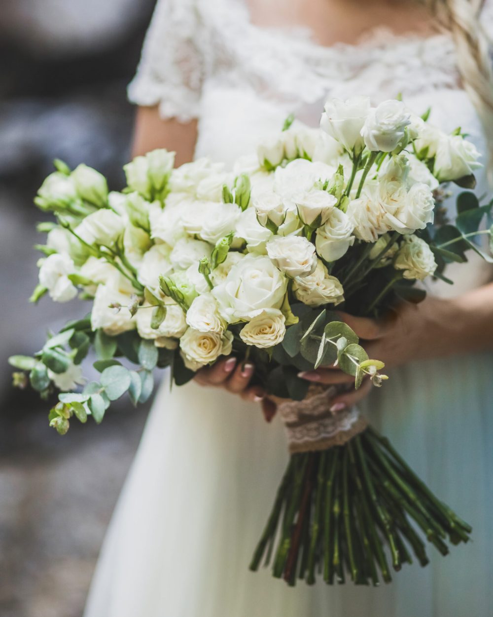 Bride holding in hands big bouquet with white roses